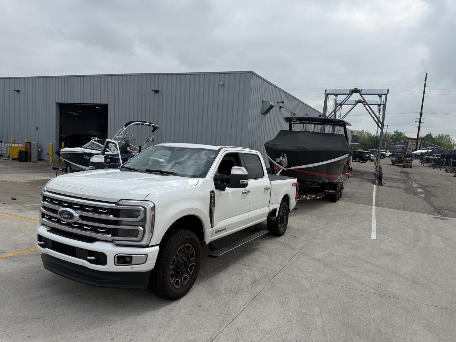 White Super Duty pulling a covered Cobalt